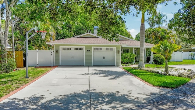 14 Evonaire Cir, Belleair, FL 33756 - ranch-style house featuring driveway, an attached garage, a gate, and a shingled roof