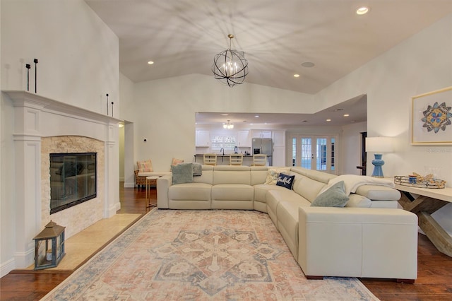 14 Evonaire Cir, Belleair, FL 33756 - living area with a fireplace, recessed lighting, vaulted ceiling, light wood-style flooring, and a chandelier