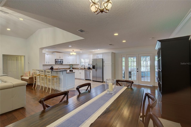 14 Evonaire Cir, Belleair, FL 33756 - dining space with light wood finished floors, a textured ceiling, recessed lighting, ornamental molding, and a chandelier