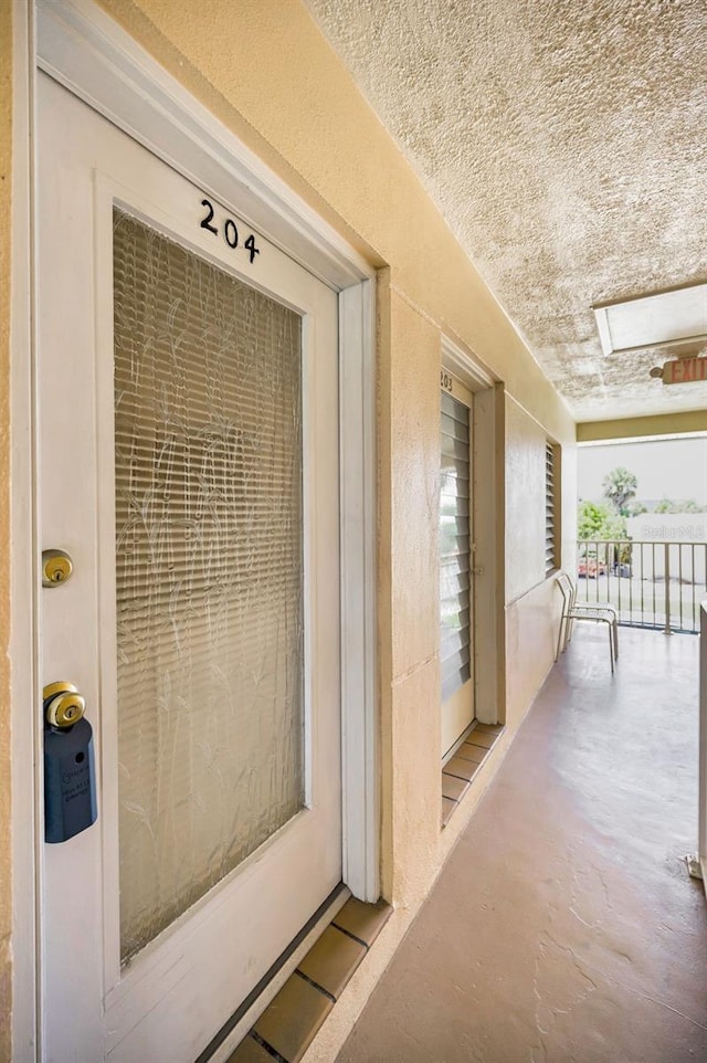 7740 Boca Ciega Dr Unit 204, St Pete Beach, FL 33706 - view of exterior entry featuring stucco siding