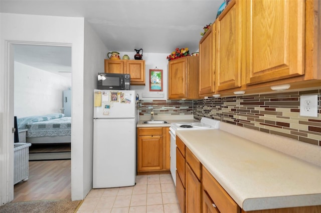 7740 Boca Ciega Dr Unit 204, St Pete Beach, FL 33706 - kitchen with white appliances, tasteful backsplash, light countertops, and brown cabinets