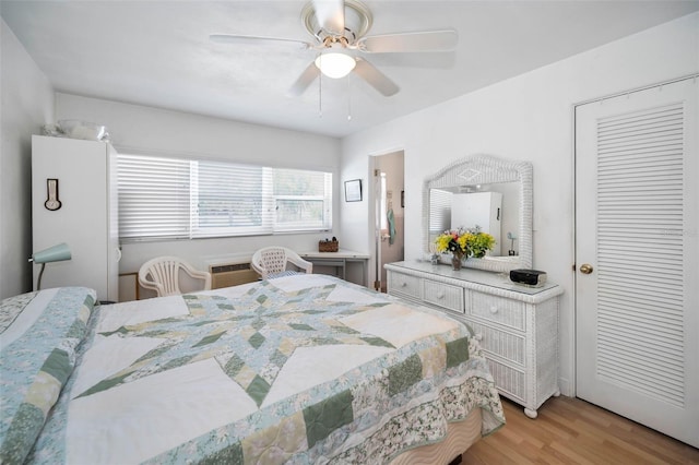7740 Boca Ciega Dr Unit 204, St Pete Beach, FL 33706 - bedroom with light wood-style floors, a ceiling fan, and a wall unit AC