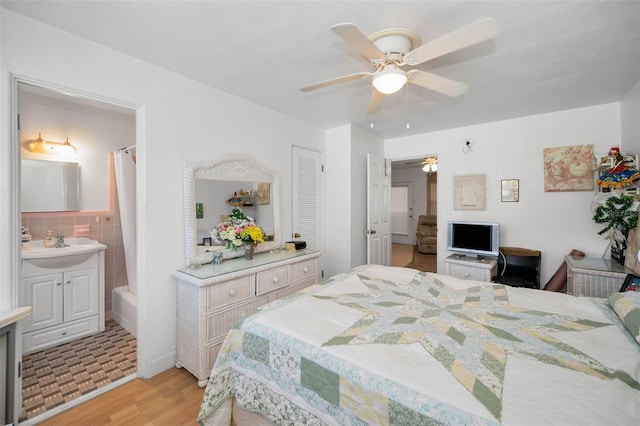 7740 Boca Ciega Dr Unit 204, St Pete Beach, FL 33706 - bedroom with light wood-style flooring, ensuite bath, and ceiling fan
