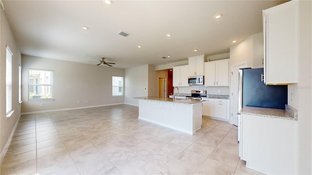 10827 High Noon Trl, Parrish, FL 34219 - kitchen with stainless steel appliances, plenty of natural light, light tile patterned flooring, ceiling fan, and recessed lighting