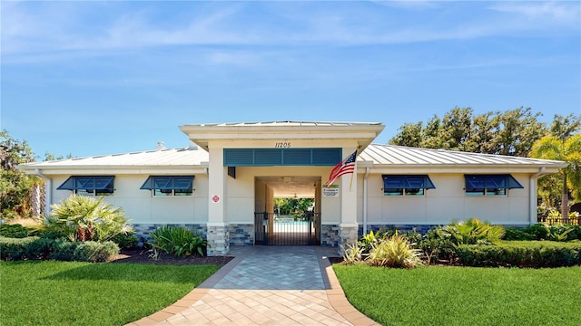 10827 High Noon Trl, Parrish, FL 34219 - view of front of property with a standing seam roof, a front lawn, a metal roof, and stone siding