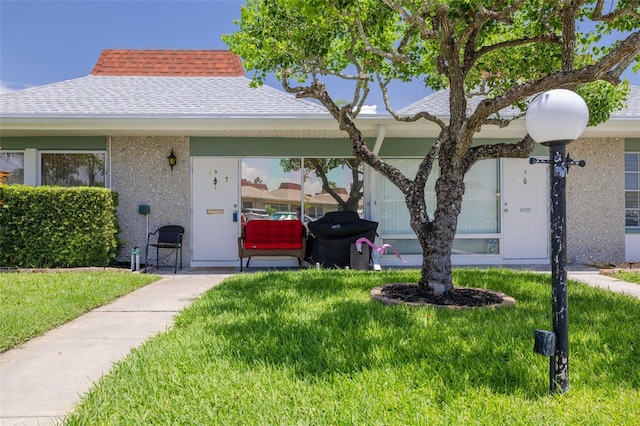 4357 Tahitian Gardens Cir Unit B, Holiday, FL 34691 - view of front of home with a shingled roof and a front lawn