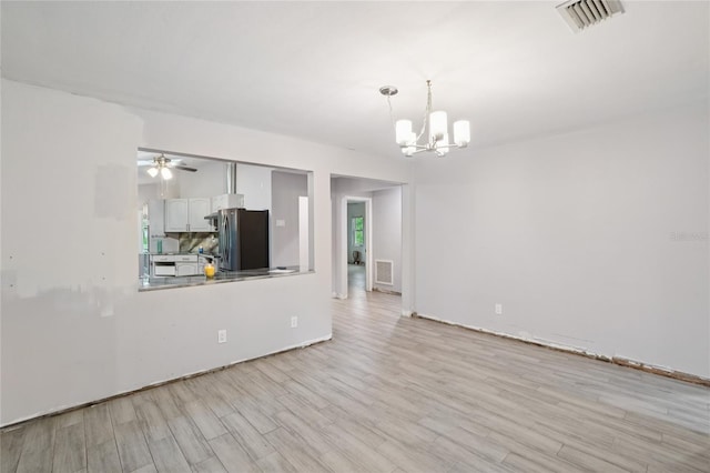 1712 Robin Hood Ln, Clearwater, FL 33764 - empty room with a chandelier, light wood finished floors, and a ceiling fan