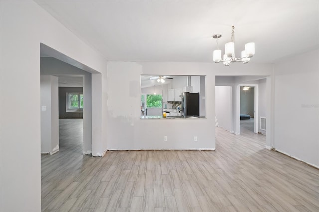 1712 Robin Hood Ln, Clearwater, FL 33764 - unfurnished living room featuring a chandelier, light wood-style flooring, and a ceiling fan