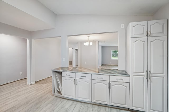 1712 Robin Hood Ln, Clearwater, FL 33764 - kitchen featuring light wood-type flooring, stainless steel countertops, a chandelier, and white cabinets