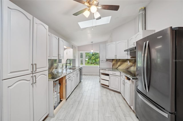 1712 Robin Hood Ln, Clearwater, FL 33764 - kitchen featuring stainless steel appliances, a skylight, a ceiling fan, vaulted ceiling, and white cabinetry