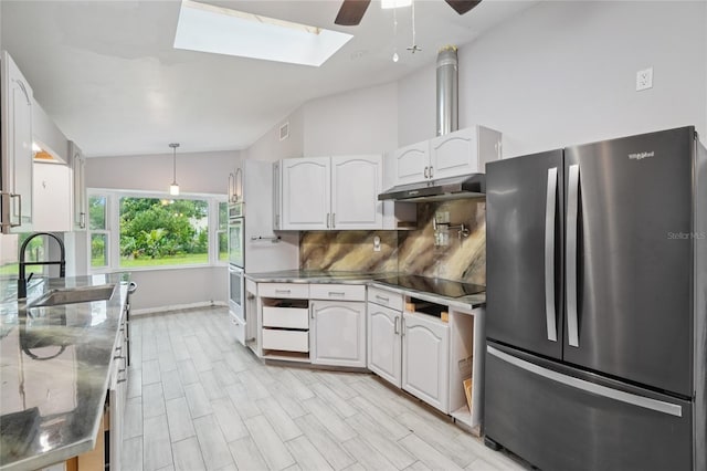 1712 Robin Hood Ln, Clearwater, FL 33764 - kitchen featuring stainless steel appliances, vaulted ceiling, stainless steel counters, ceiling fan, and a skylight