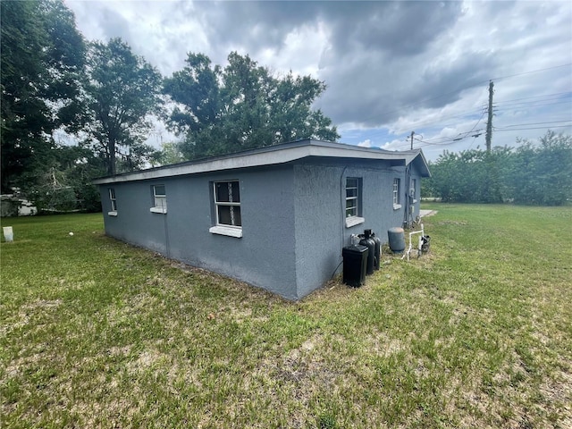 1225 Nemeth St, Auburndale, FL 33823 - view of side of home with stucco siding and a lawn