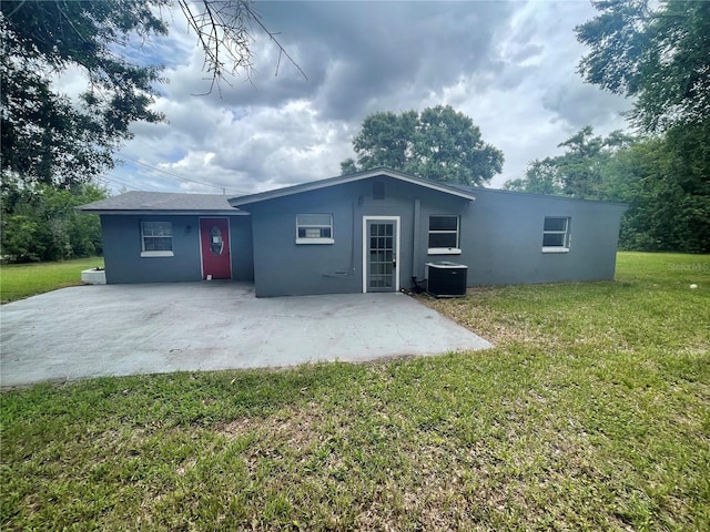 1225 Nemeth St, Auburndale, FL 33823 - rear view of house with stucco siding, a lawn, and a patio area