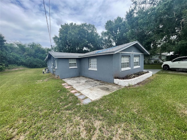 1225 Nemeth St, Auburndale, FL 33823 - view of side of home featuring stucco siding, a yard, and a patio