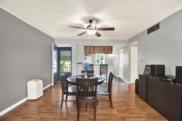 250 Cypress Ln, Oldsmar, FL 34677 - dining space featuring light wood-style flooring, ceiling fan, and a textured ceiling