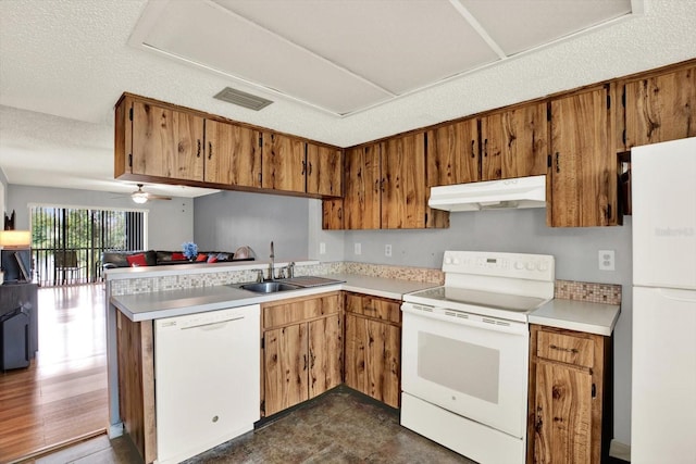 250 Cypress Ln, Oldsmar, FL 34677 - kitchen featuring white appliances, under cabinet range hood, a peninsula, light countertops, and brown cabinets