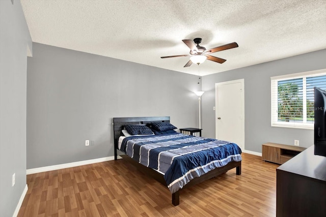 250 Cypress Ln, Oldsmar, FL 34677 - bedroom with light wood finished floors, a textured ceiling, and a ceiling fan
