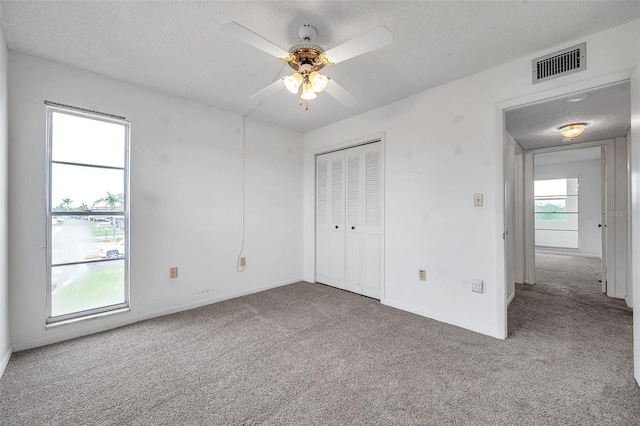 5245 Amulet Dr Unit 201, New Port Richey, FL 34652 - unfurnished bedroom with carpet floors, a textured ceiling, a closet, and ceiling fan