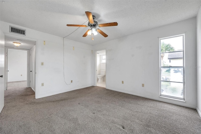5245 Amulet Dr Unit 201, New Port Richey, FL 34652 - spare room featuring carpet floors, healthy amount of natural light, ceiling fan, and a textured ceiling