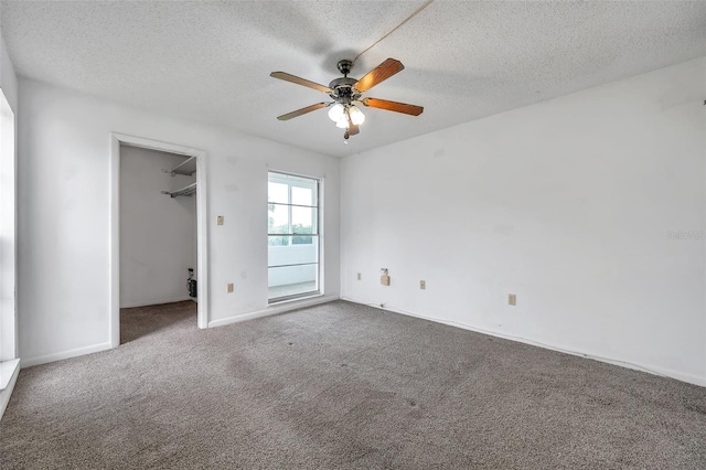 5245 Amulet Dr Unit 201, New Port Richey, FL 34652 - unfurnished bedroom with a textured ceiling, carpet flooring, a spacious closet, and ceiling fan
