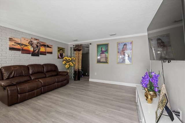 1712 W Atkinson St, Tampa, FL 33604 - living room with light wood-style flooring, crown molding, a textured ceiling, and brick wall