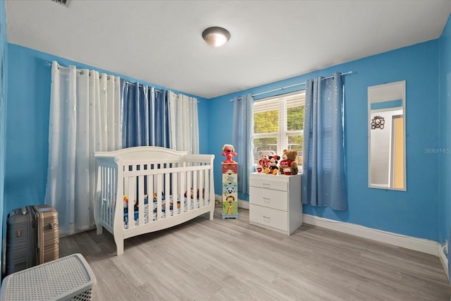 1712 W Atkinson St, Tampa, FL 33604 - bedroom featuring wood finished floors and a nursery area