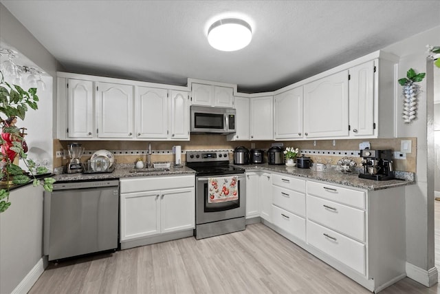 1712 W Atkinson St, Tampa, FL 33604 - kitchen with stainless steel appliances, white cabinets, and light wood-style floors