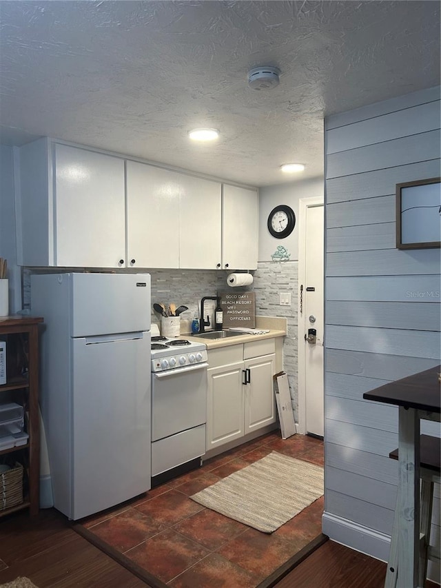 483 E Shore Dr Unit B4, Clearwater Beach, FL 33767 - kitchen with white appliances, a textured ceiling, decorative backsplash, white cabinetry, and light countertops