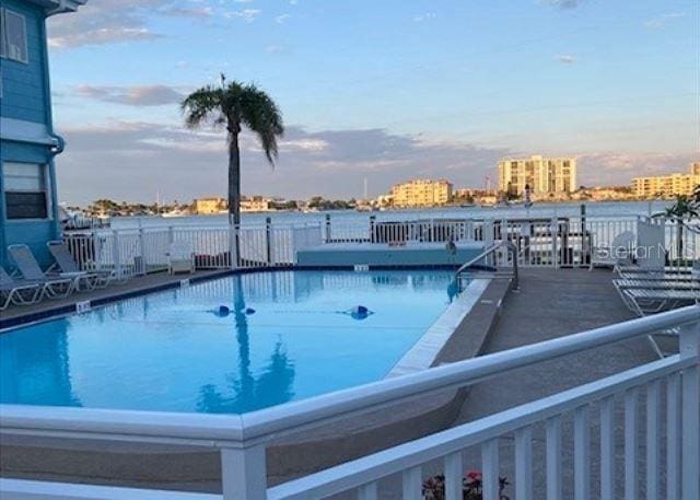 483 E Shore Dr Unit B4, Clearwater Beach, FL 33767 - pool at dusk featuring a community pool and a view of city