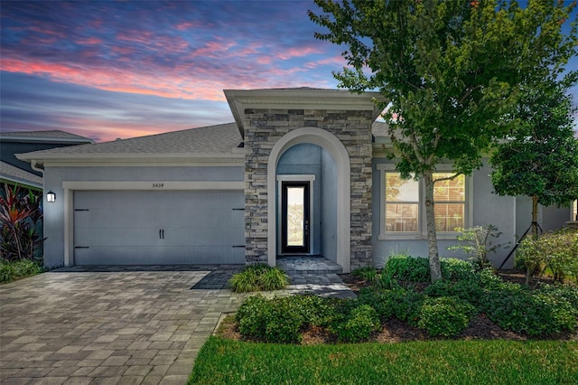 5434 Silver Sun Dr, Apollo Beach, FL 33572 - view of front of house with a garage, stucco siding, decorative driveway, and stone siding