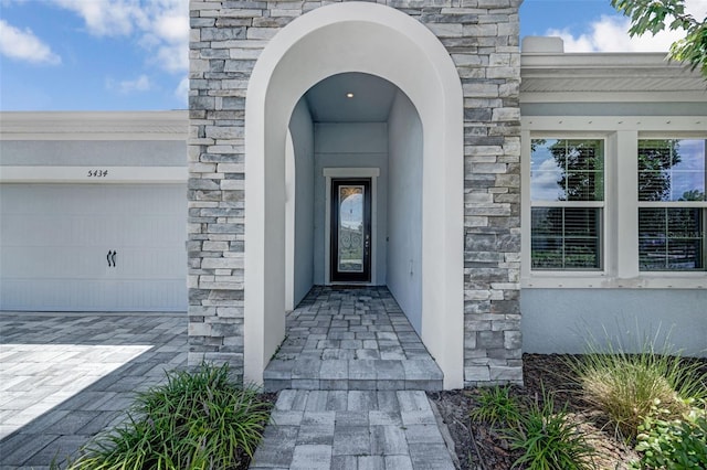 5434 Silver Sun Dr, Apollo Beach, FL 33572 - doorway to property featuring stone siding and a garage
