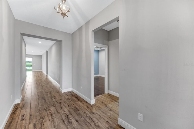 5434 Silver Sun Dr, Apollo Beach, FL 33572 - hallway featuring wood finished floors, a chandelier, and recessed lighting