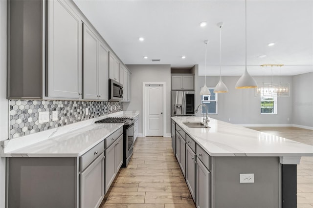 5434 Silver Sun Dr, Apollo Beach, FL 33572 - kitchen featuring gray cabinets, stainless steel appliances, light wood-style floors, decorative backsplash, and recessed lighting
