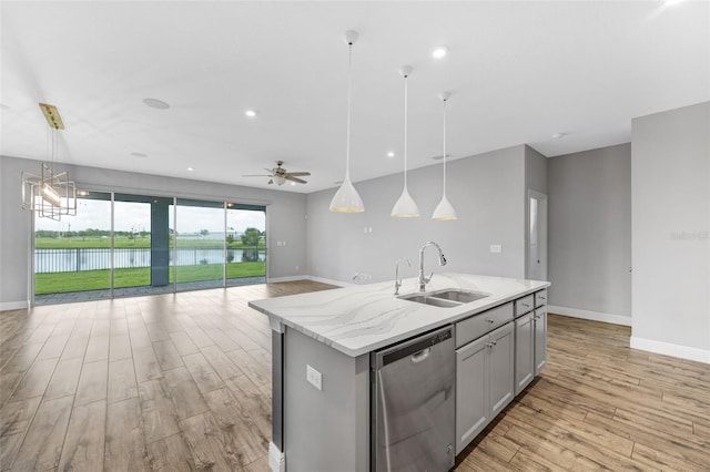 5434 Silver Sun Dr, Apollo Beach, FL 33572 - kitchen with stainless steel dishwasher, light wood-style floors, gray cabinets, open floor plan, and ceiling fan