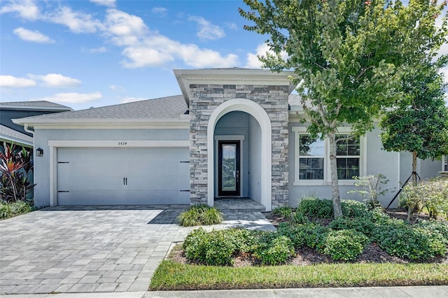 5434 Silver Sun Dr, Apollo Beach, FL 33572 - view of front of house with stone siding, stucco siding, and a garage