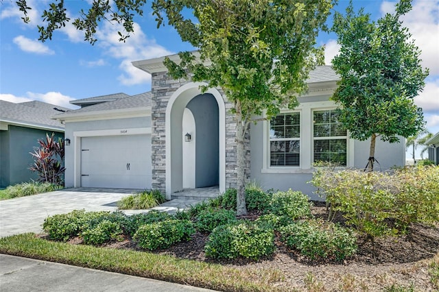 5434 Silver Sun Dr, Apollo Beach, FL 33572 - view of front of house with stucco siding, a garage, decorative driveway, and stone siding