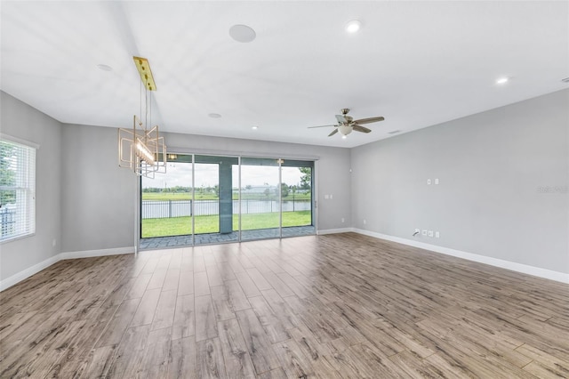 5434 Silver Sun Dr, Apollo Beach, FL 33572 - empty room with wood finished floors, plenty of natural light, a chandelier, and recessed lighting