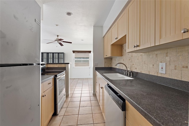 3753 46th Ave S Unit 10, Saint Petersburg, FL 33711 - kitchen with appliances with stainless steel finishes, backsplash, light tile patterned floors, dark countertops, and a ceiling fan