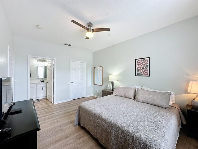 2300 Butterfly Palm Way Unit 204, Kissimmee, FL 34747 - bedroom featuring light wood-type flooring, a ceiling fan, and connected bathroom