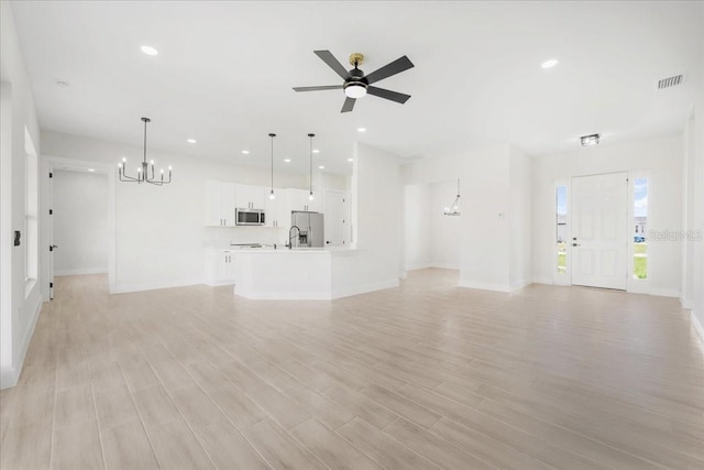 437 Mercedes Ct, Lehigh Acres, FL 33972 - unfurnished living room featuring a chandelier, recessed lighting, light wood-style floors, and ceiling fan