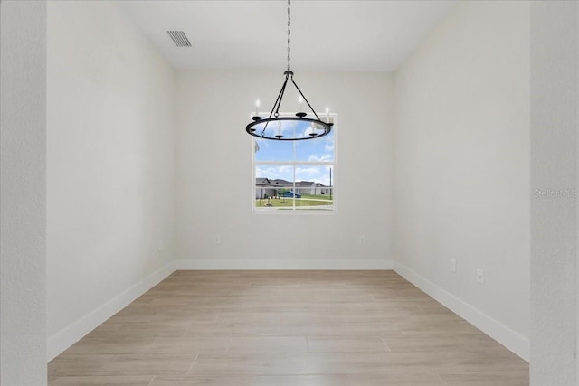 437 Mercedes Ct, Lehigh Acres, FL 33972 - spare room featuring a chandelier and light wood finished floors