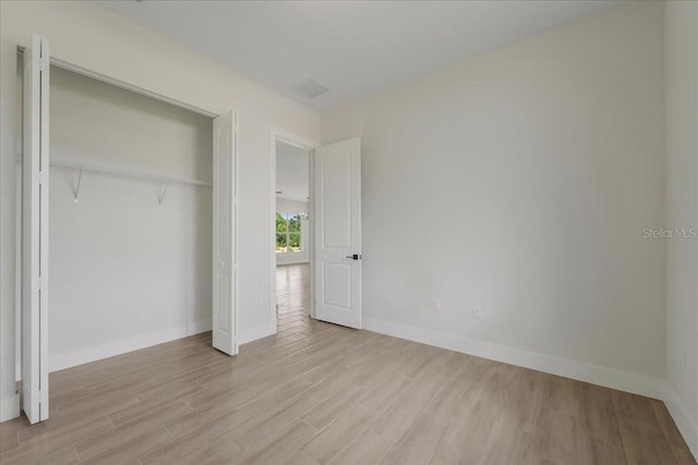 437 Mercedes Ct, Lehigh Acres, FL 33972 - unfurnished bedroom with wood finished floors and a closet