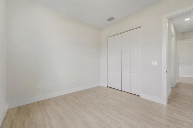 437 Mercedes Ct, Lehigh Acres, FL 33972 - unfurnished bedroom featuring light wood-style floors and a closet