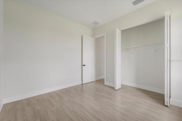 437 Mercedes Ct, Lehigh Acres, FL 33972 - unfurnished bedroom featuring light wood finished floors and a closet
