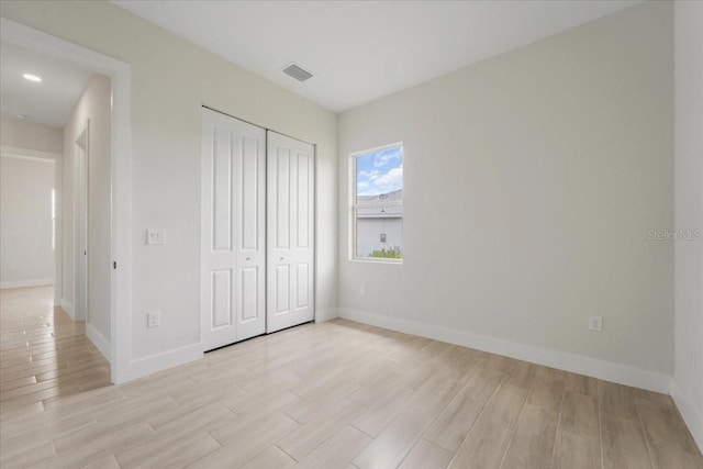 437 Mercedes Ct, Lehigh Acres, FL 33972 - unfurnished bedroom with light wood-style flooring and a closet