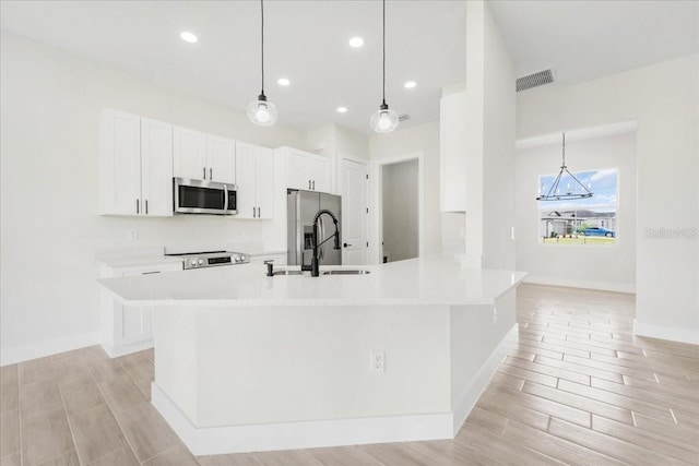 437 Mercedes Ct, Lehigh Acres, FL 33972 - kitchen with stainless steel appliances, white cabinets, light wood-style floors, and recessed lighting