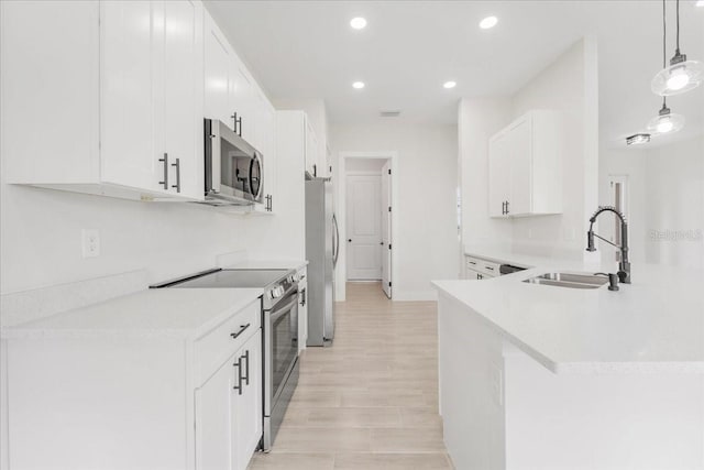 437 Mercedes Ct, Lehigh Acres, FL 33972 - kitchen featuring stainless steel appliances, white cabinets, light countertops, recessed lighting, and decorative light fixtures