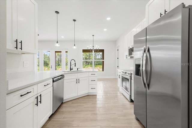 437 Mercedes Ct, Lehigh Acres, FL 33972 - kitchen with stainless steel appliances, a peninsula, recessed lighting, light countertops, and white cabinets