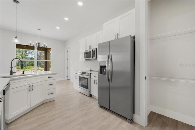 437 Mercedes Ct, Lehigh Acres, FL 33972 - kitchen with stainless steel appliances, white cabinetry, recessed lighting, light countertops, and light wood-style flooring