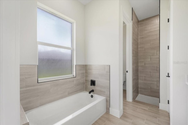 437 Mercedes Ct, Lehigh Acres, FL 33972 - bathroom featuring plenty of natural light, a garden tub, and wood tiled floors